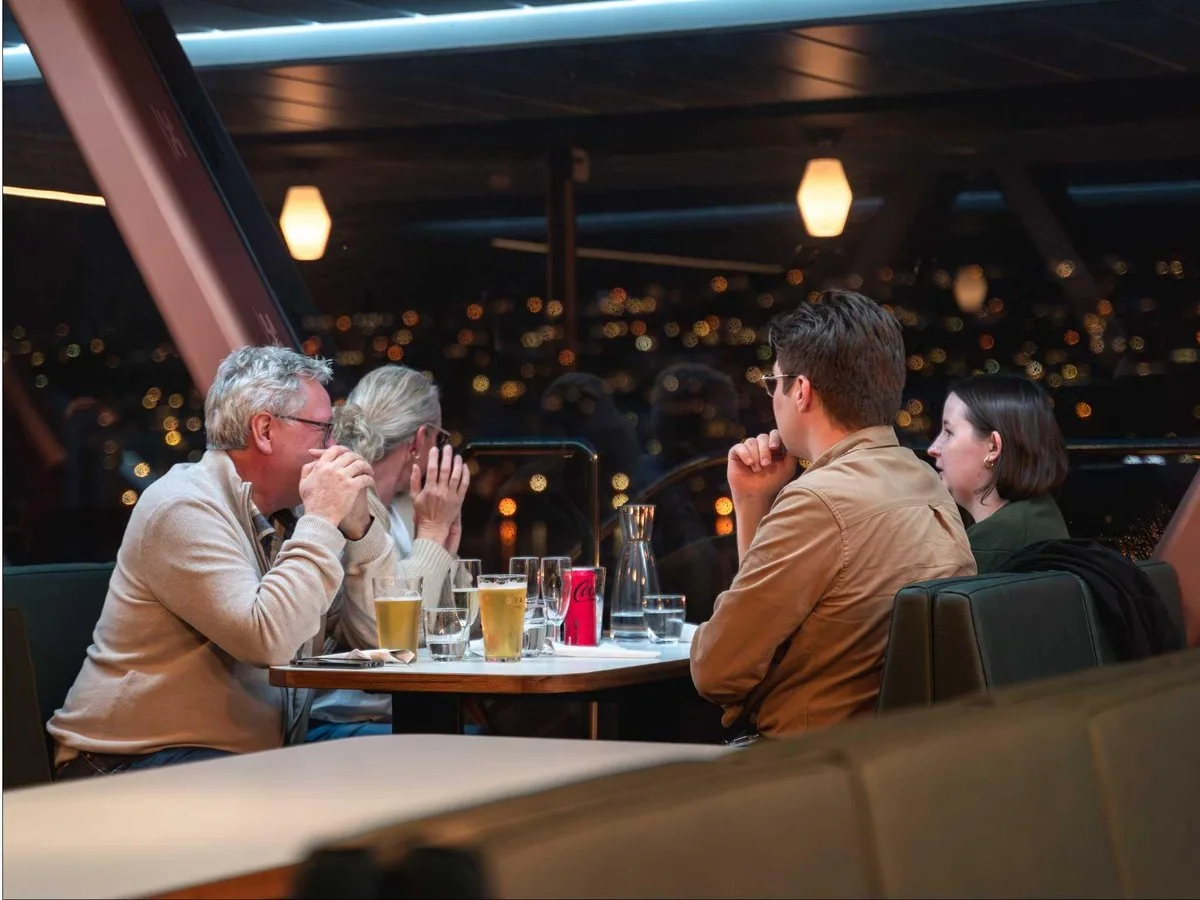 Guests dining inside the illuminated cabin